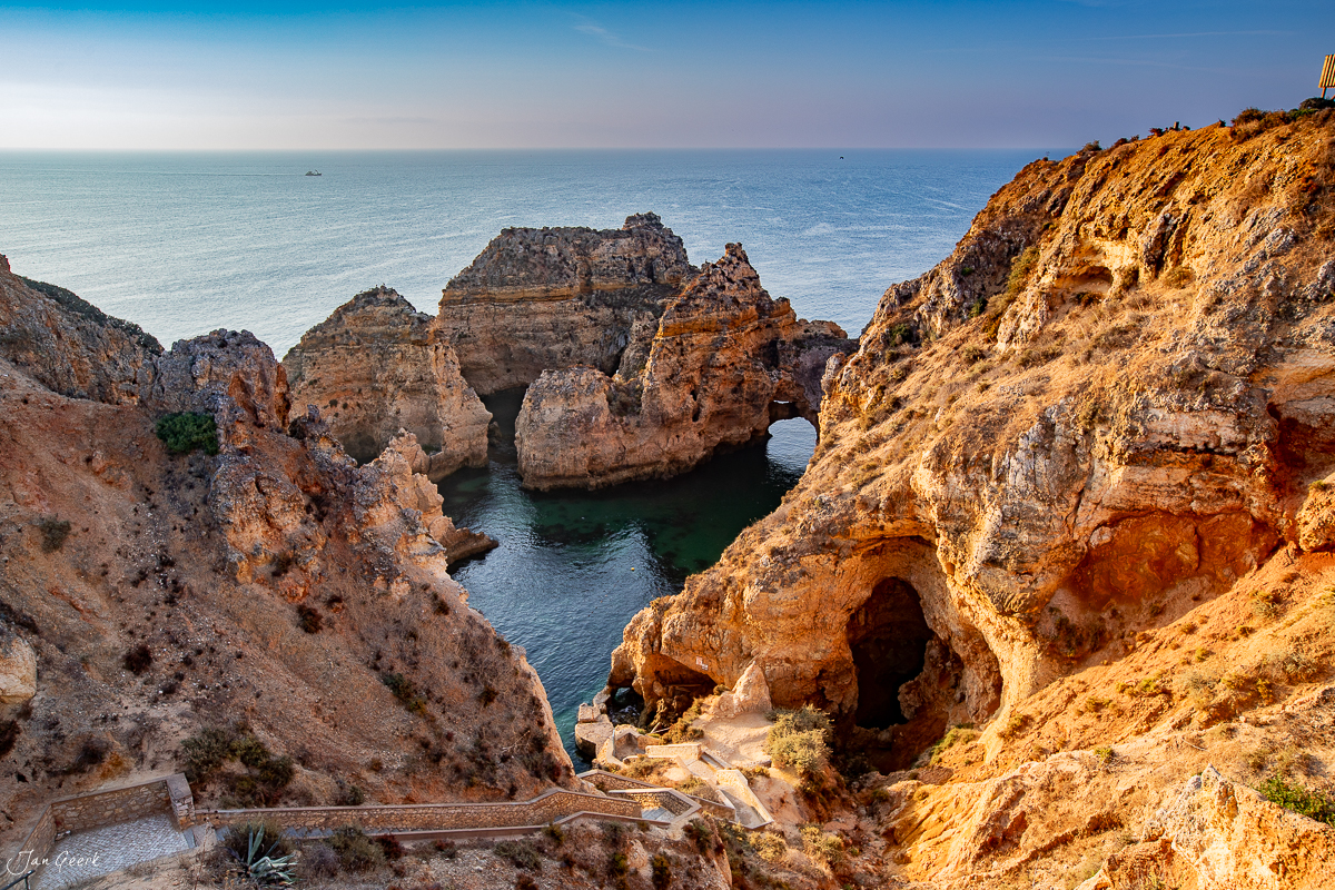 Felsküste mit Naturbogen und Meereshöhlen in Lagos, Algarve, Sommerlicht – Jan Geerk Fotograf Basel