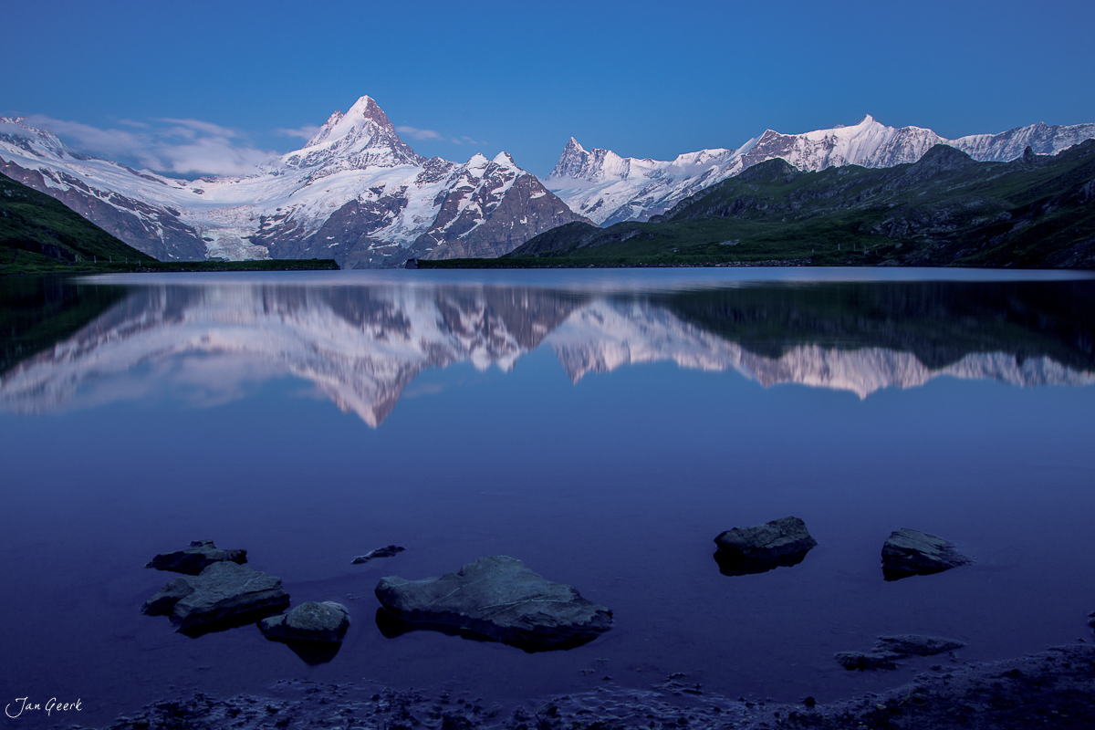 Bachalpsee mit schneebedeckten Bergen Schreckhorn und Wetterhorn spiegeln sich im klaren Bergsee, Sommer im Berner Oberland Schweiz – Jan Geerk Fotograf Basel