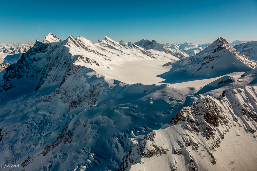 Schneebedeckte Bergkette Jungfrau mit Gletscher und Alpenpanorama bei Sonnenschein im Winter, Berner Oberland Schweiz – Jan Geerk Fotograf Basel