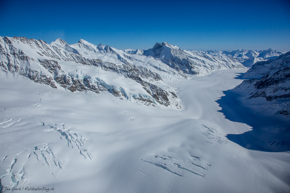 Verschneite Gletscherlandschaft mit Bergketten im Berner Oberland unter blauem Himmel, Winter in der Schweiz – Jan Geerk Fotograf Basel