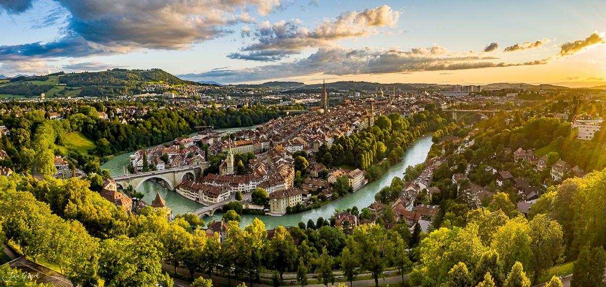 Luftaufnahme der Altstadt Bern mit Aare-Schlaufe, Münster und grünen Wäldern bei Sommersonnenlicht, Schweiz – Jan Geerk Fotograf Basel
