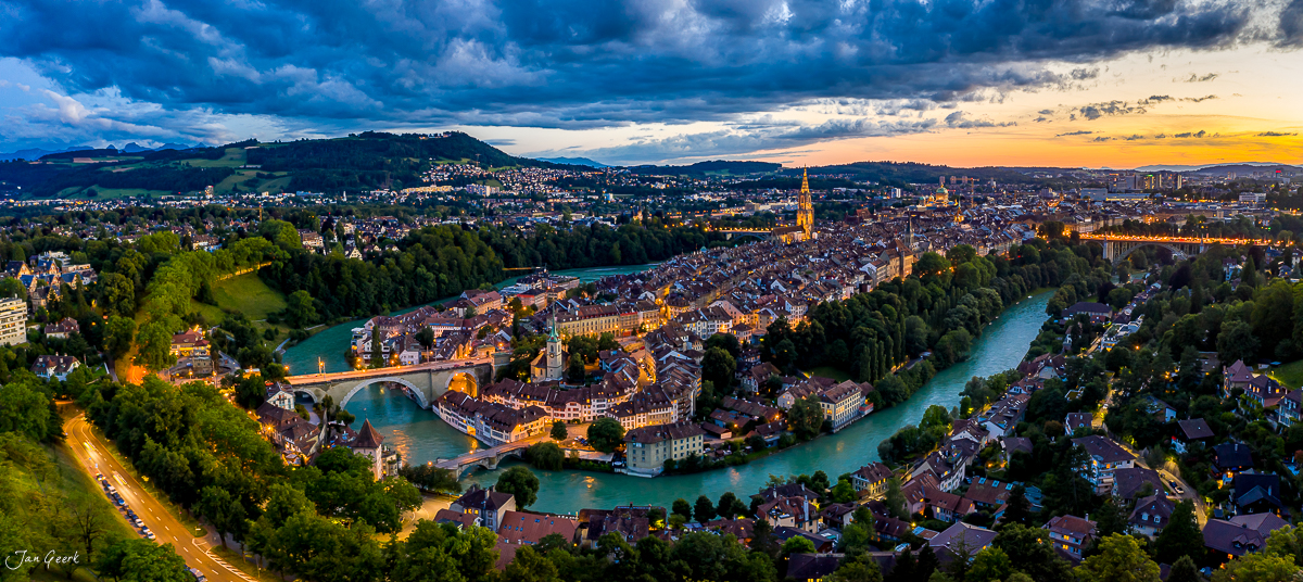 Luftaufnahme der Aareschlaufe in Bern mit beleuchteter Altstadt, Münster und Fluss in Sommerstimmung, Berneroberland Schweiz – Jan Geerk Fotograf Basel
