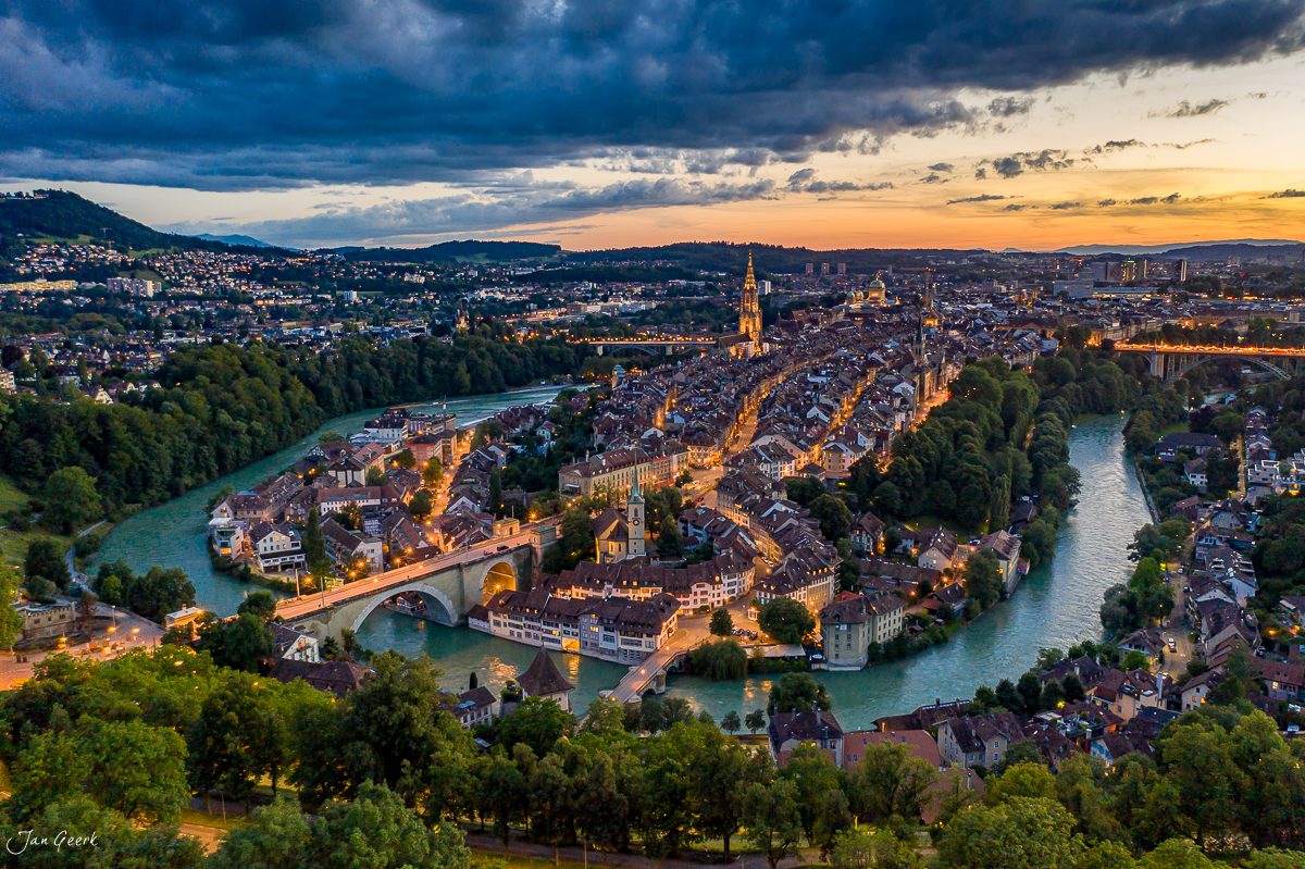 Luftaufnahme der Altstadt Bern mit Aare-Schleife, beleuchtete Häuser und Münster bei Sonnenuntergang, Schweiz – Jan Geerk Fotograf Basel