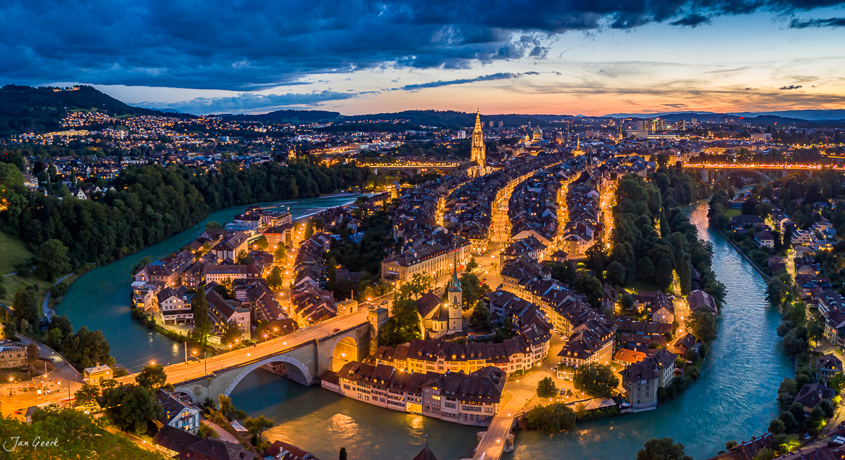 Luftaufnahme der Altstadt Bern mit Aare-Schleife, Münster und beleuchteten Gassen bei Sonnenuntergang, Berner Oberland Schweiz – Jan Geerk Fotograf Basel