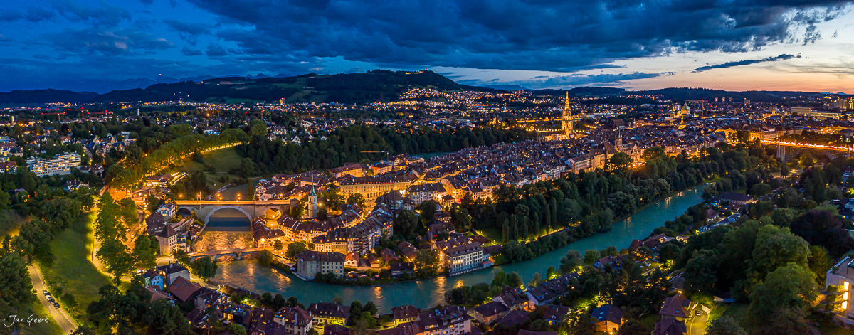 Luftaufnahme von Bern mit Aareschlaufe und beleuchteter Altstadt in der Abenddämmerung, Schweiz – Jan Geerk Fotograf Basel