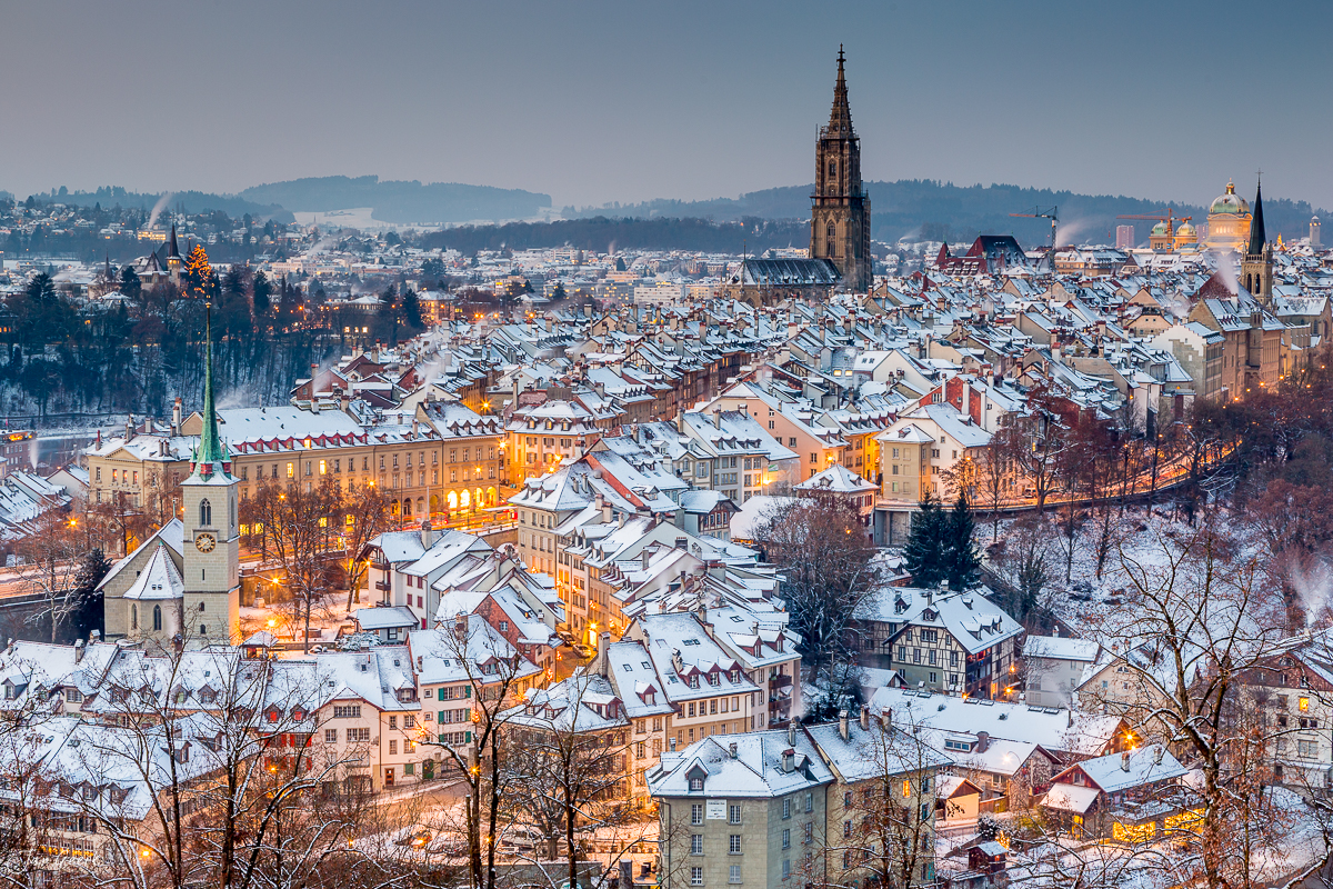 Winterliche Altstadt Bern mit schneebedeckten Dächern, Münster und Alpen im Hintergrund – Jan Geerk Fotograf Basel