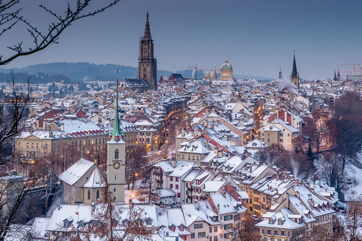 Verschneite Altstadt von Bern mit Münster im Winter, Alpen im Hintergrund, Schweiz – Jan Geerk Fotograf Basel