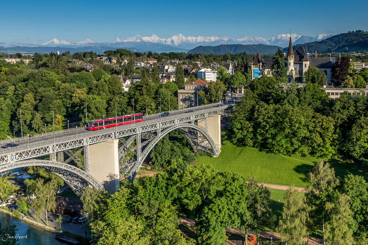Rote Bahn überquert Viadukt über grüne Landschaft mit Alpensicht in Bern Sommer Schweiz – Jan Geerk Fotograf Basel