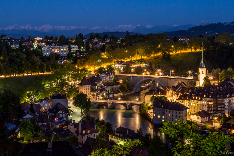 Nächtliche Stadtansicht von Bern mit beleuchteter Altstadt, Fluss und Kirchturm, Alpensicht im Hintergrund, Sommernacht Schweiz – Jan Geerk Fotograf Basel