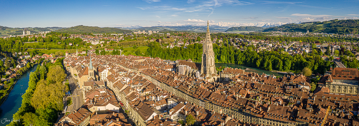 Luftaufnahme der Altstadt Bern mit Münster und Aareschlaufe im Frühling, Alpen im Hintergrund – Jan Geerk Fotograf Basel