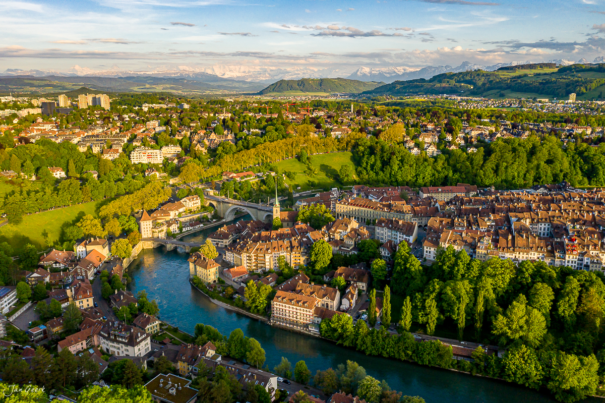 Luftaufnahme Bern Altstadt mit Aare-Schleife, Frühlingslicht, Alpen im Hintergrund, Schweiz – Jan Geerk Fotograf Basel