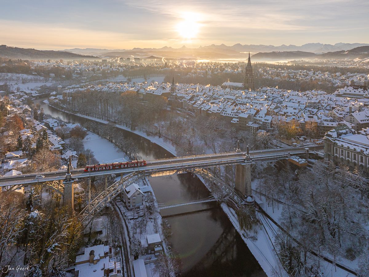 Bahnviadukt mit Zug über die Aareschlaufe in Bern im Schnee bei Sonnenaufgang, Alpen im Hintergrund, Schweiz – Jan Geerk Fotograf Basel