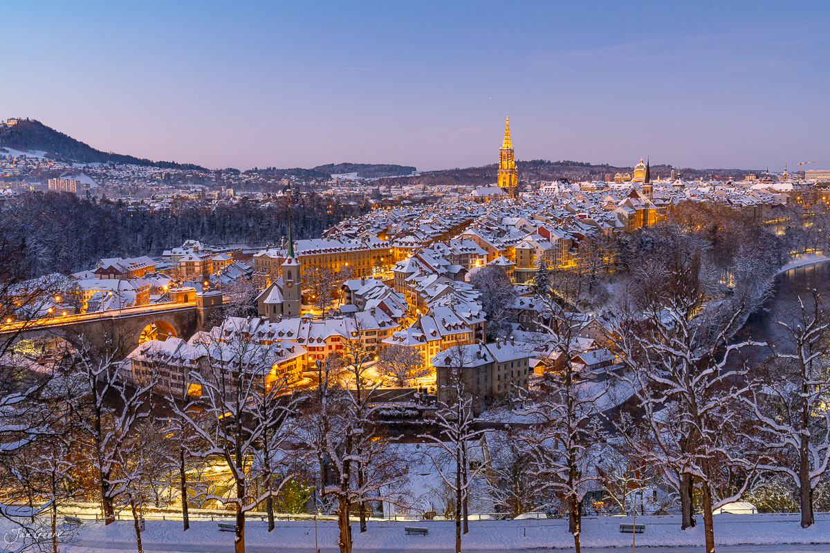 Schneebedeckte Altstadt Bern im Wintermorgen mit beleuchteten Kirchen und Dächern – Jan Geerk Fotograf Basel Schweiz