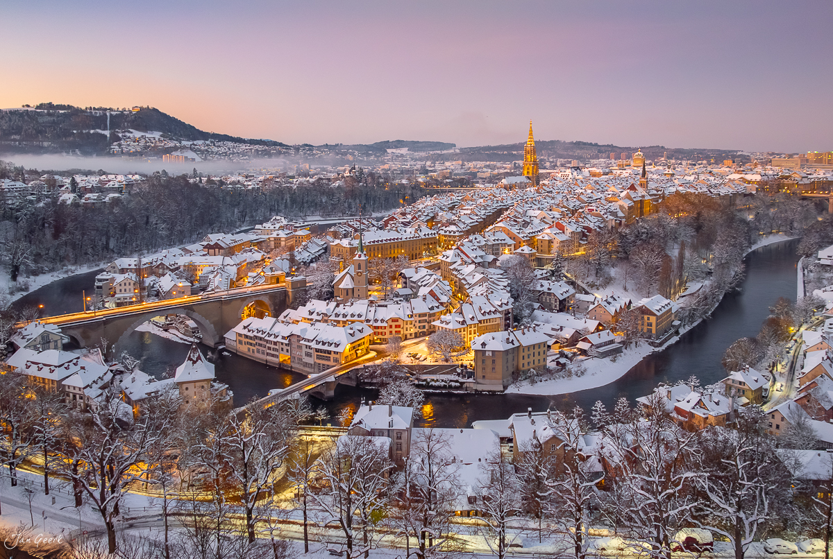 Winterliche Altstadt Bern mit schneebedeckten Dächern, Münster und Aareschlaufe im Sonnenaufganglicht, Schweiz – Jan Geerk Fotograf Basel