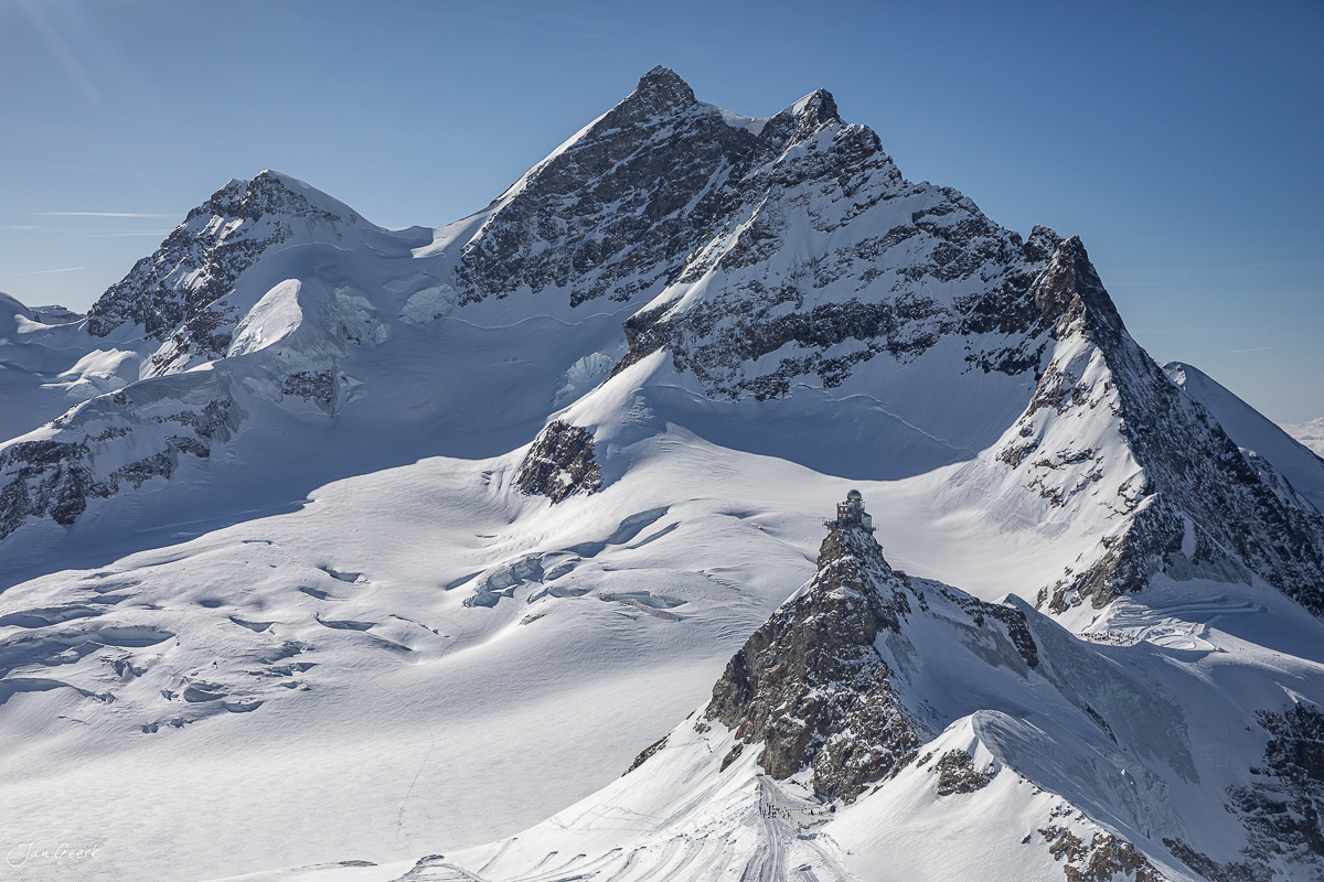 Schneebedeckte Berggipfel am Jungfraujoch im Berner Oberland mit klarem Winterhimmel – Jan Geerk Fotograf Basel