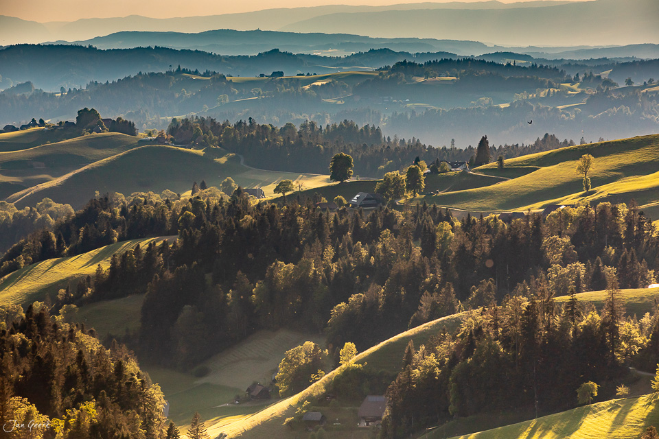 Luftaufnahme der Emmental Hügellandschaft mit Wäldern und grünen Wiesen bei Sommersonnenlicht Schweiz Jan Geerk Fotograf Basel