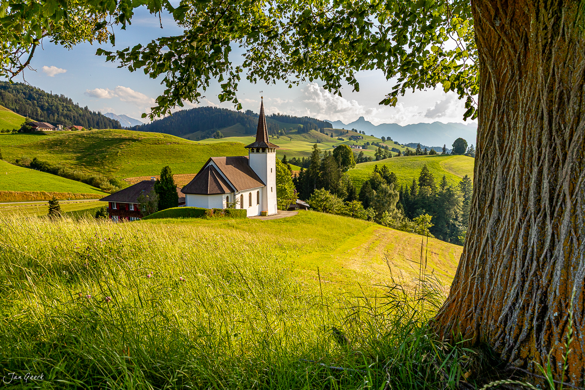 Kirche im Emmental mit grünen Hügeln, Bergblick, Sommerwald, Berner Oberland Schweiz – Jan Geerk Fotograf Basel