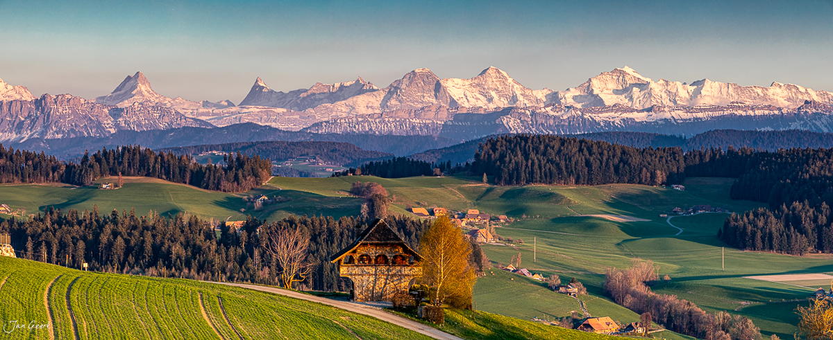Traditionelles Chalet in Biglen mit Blick auf Eiger, Jungfrau und Mönch im Frühling, Berner Oberland Schweiz – Jan Geerk Fotograf Basel