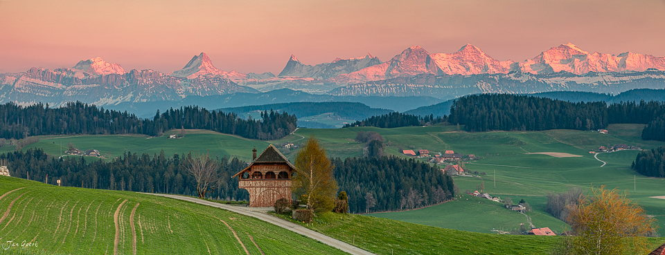 Spycher Bauernhaus mit Frühjahrsglanz in Biglen, Alpensicht auf Eiger Jungfrau Mönch, Emmental Berner Oberland Schweiz – Jan Geerk Fotograf Basel