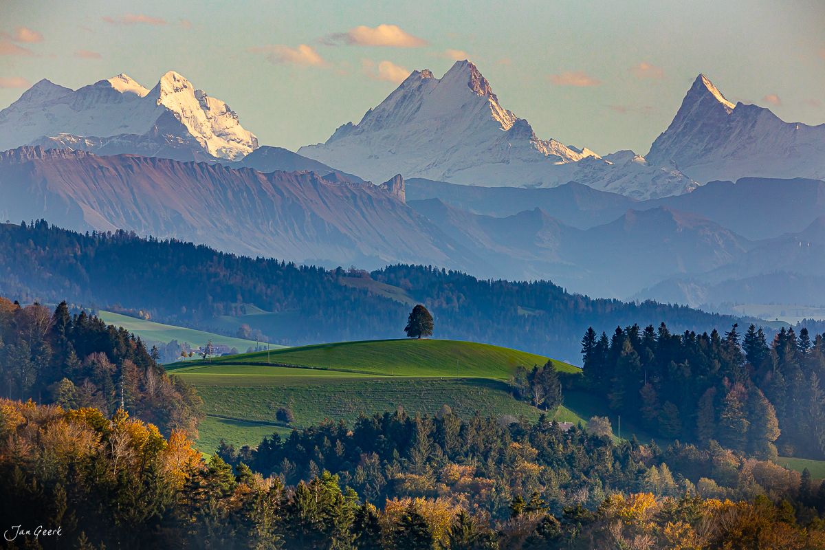 Herbstliche Alpenlandschaft bei Emmental mit schneebedeckten Gipfeln und grünen Hügeln, Schweiz – Jan Geerk Fotograf Basel