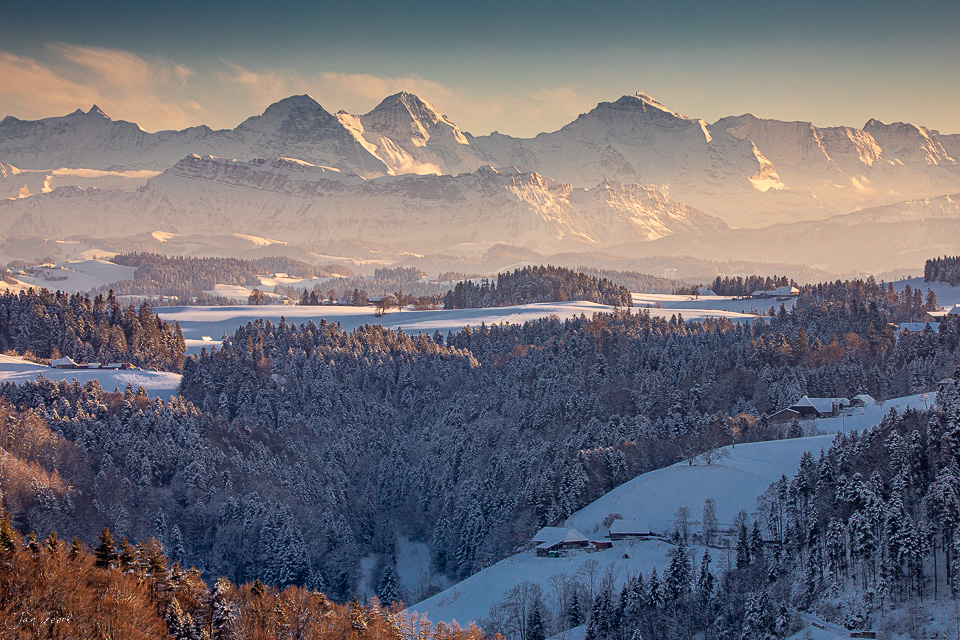 Winterlandschaft Ferrenberg mit schneebedeckten Wäldern, Seen und Alpenpanorama bei Kantlicht, Emmental Berner Oberland Schweiz – Jan Geerk Fotograf Basel