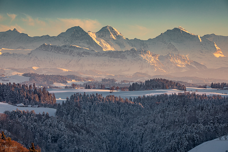 Winterliche Berglandschaft im Emmental mit verschneiten Fichtenwäldern, Alpensicht auf Eiger, Mönch und Jungfrau bei Sonnenaufgang, Berner Oberland Schweiz – Jan Geerk Fotograf Basel