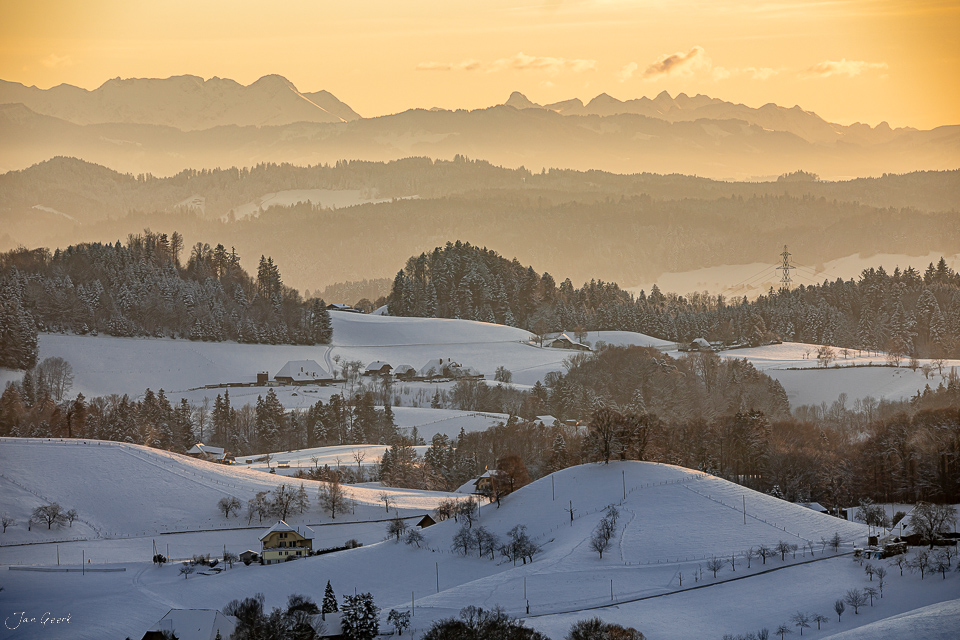 Verschneite Hügellandschaft Emmental mit Alpenpanorama im goldenen Morgenlicht, Berner Oberland Schweiz – Jan Geerk Fotograf Basel