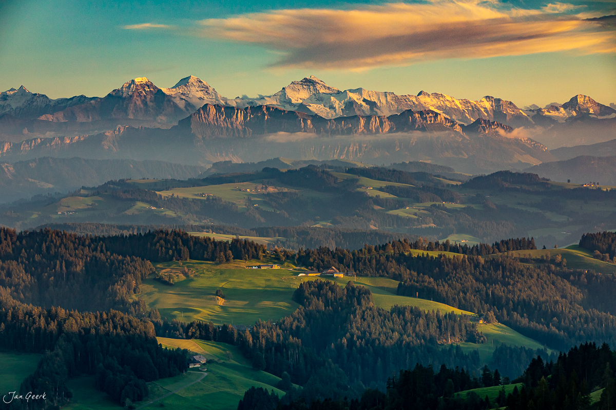 Alpensicht vom Emmental über grüne Hügel zu Eiger, Jungfrau und Mönch bei goldenem Kantlicht – Schweiz, Jan Geerk Fotograf Basel
