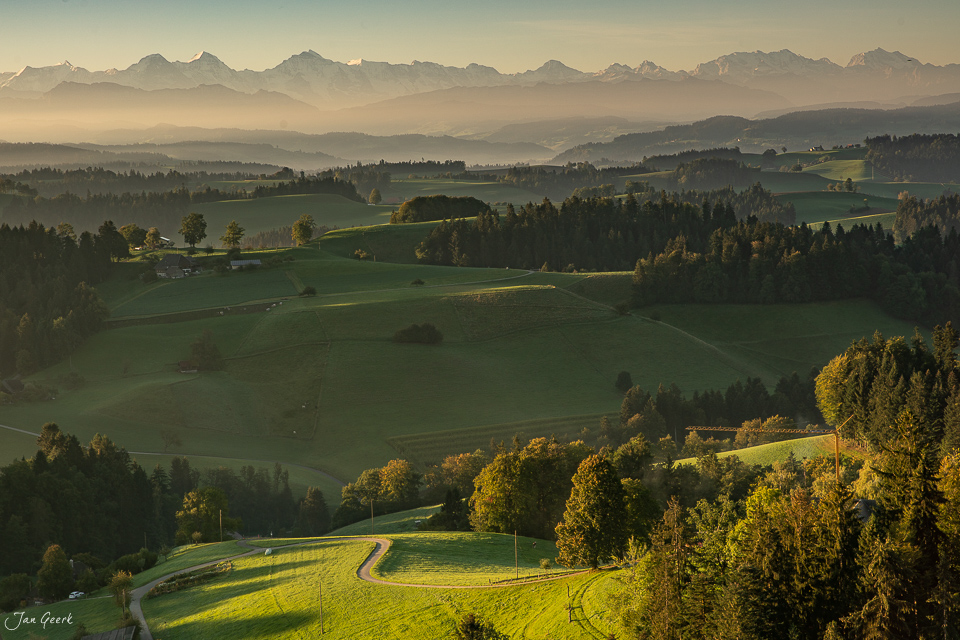 Grüne Hügellandschaft im Emmental mit Alpensicht bei goldener Stimmung, Schweiz – Jan Geerk Fotograf Basel