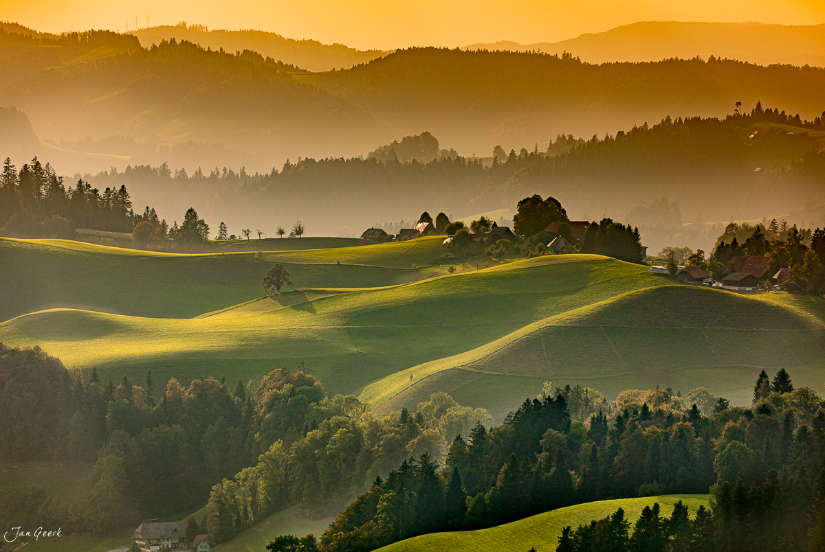 Hügelige Landschaft im Emmental mit goldener Morgensonne, grünen Wiesen und Wäldern, Kanton Bern Schweiz – Jan Geerk Fotograf Basel