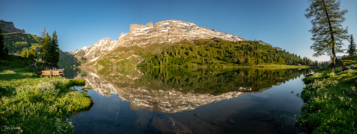 Engstlensee mit spiegelnder Wasseroberfläche, umgeben von Bergen und Nadelwäldern, Sommerstimmung in der Schweiz – Jan Geerk Fotograf Basel