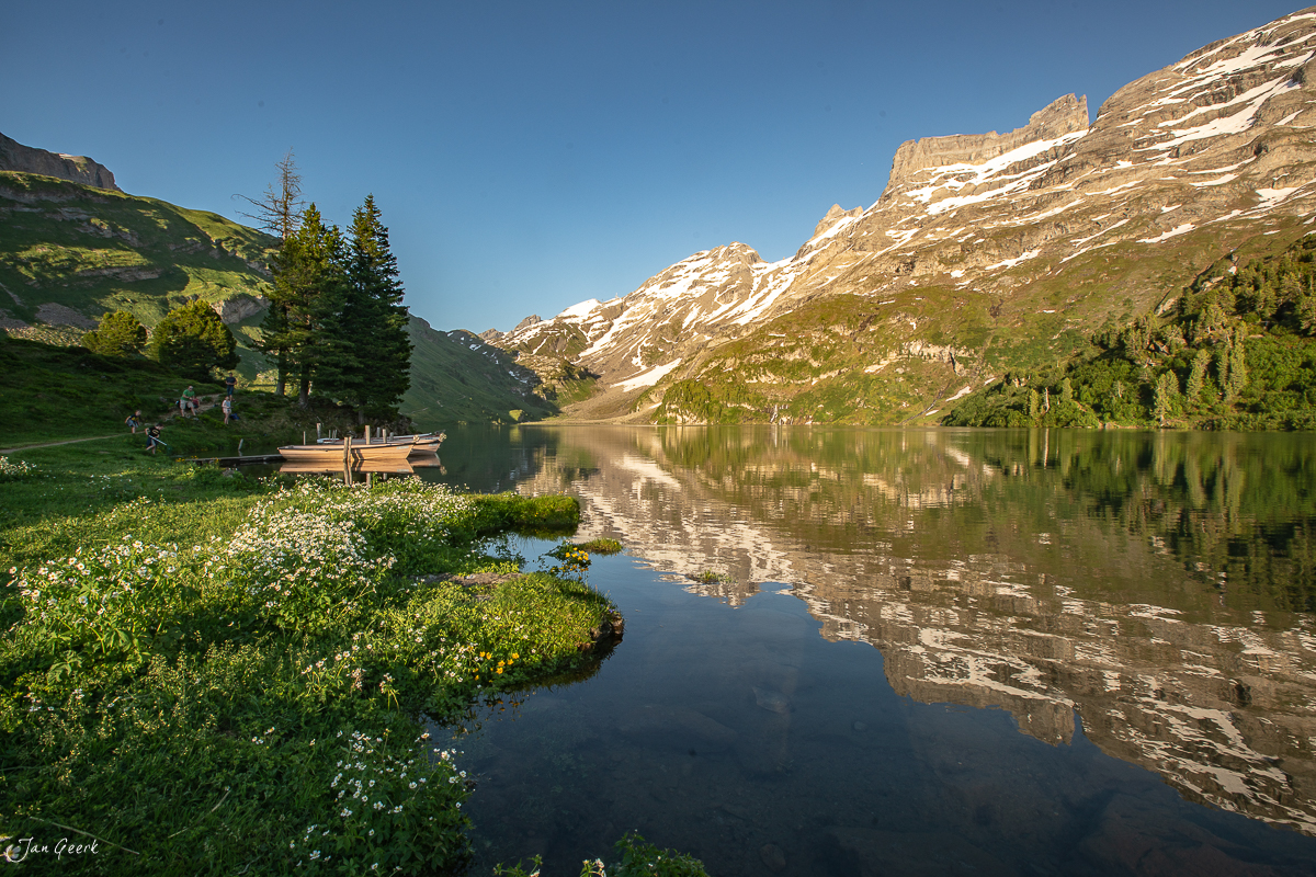 Engstlensee mit Alpwiese, Berghütte und Spiegelungen der Bergkette Engstlenalp im Sommer, Berner Oberland Schweiz – Jan Geerk Fotograf Basel