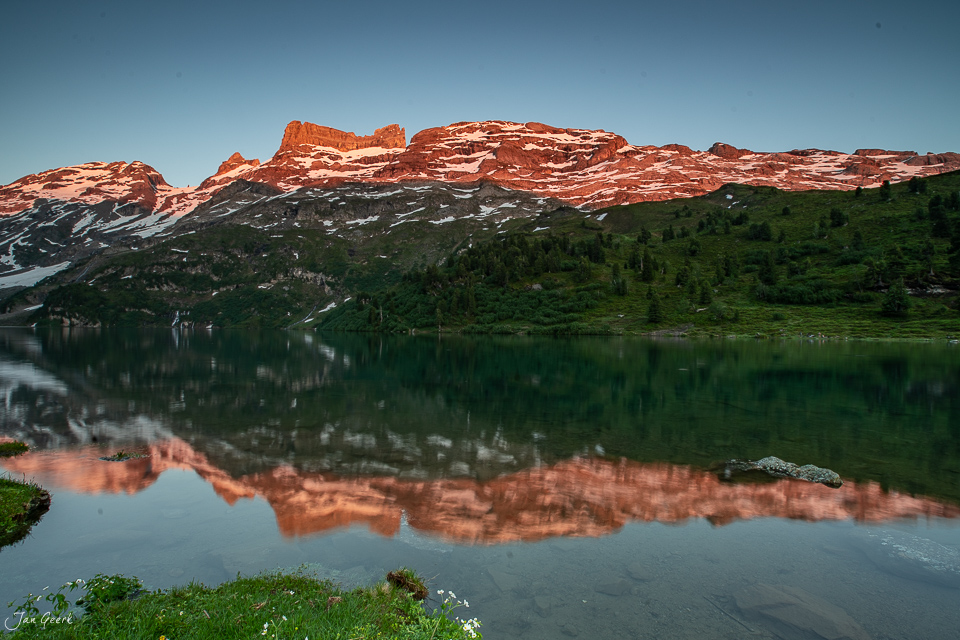 Alpensee mit Spiegelung roter Felswände am Engstlensee Berneroberland Sommer Luftaufnahme Schweiz Jan Geerk Fotograf Basel