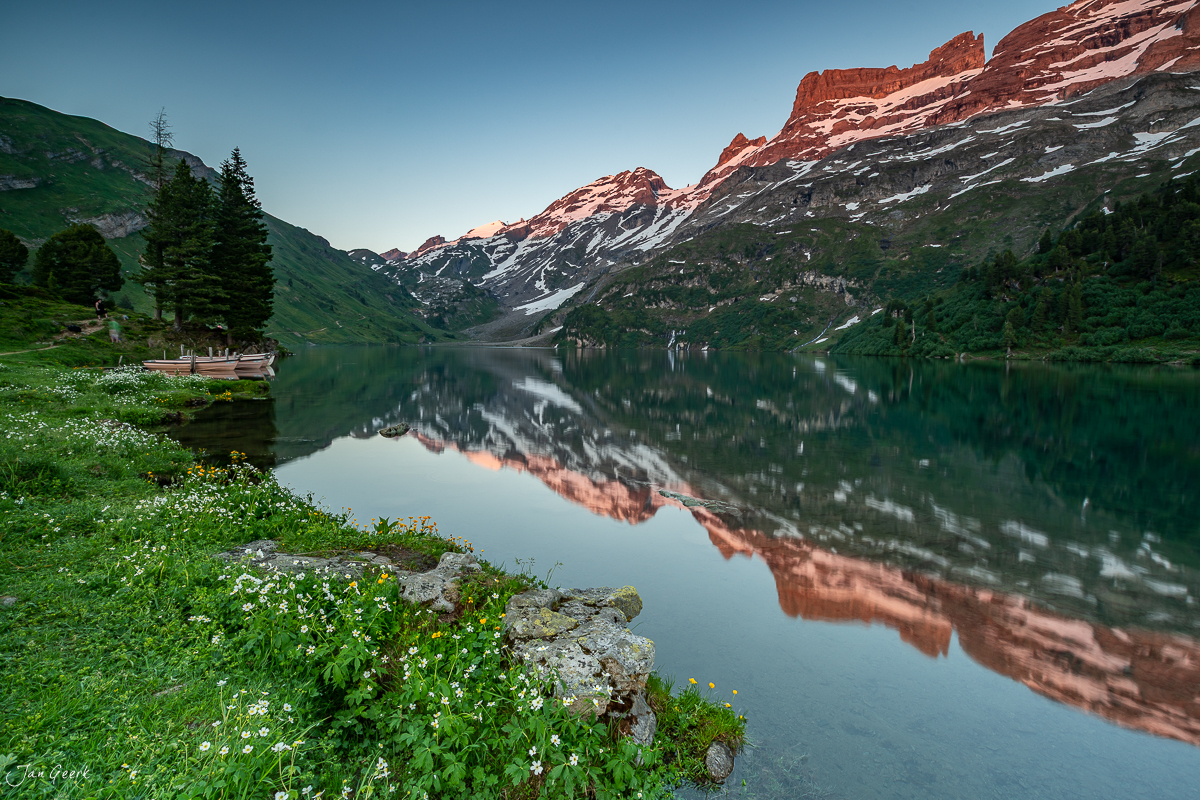 Alpensee mit Spiegelung der roten Felswände am Engstlensee bei Sommerlicht, Berner Oberland Schweiz – Jan Geerk Fotograf Basel