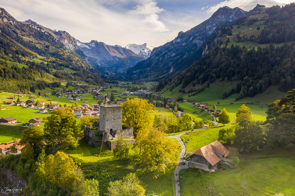 Mittelalterliche Burgruine über grünem Dorf in Berglandschaft, Sommer, Berner Oberland Schweiz – Jan Geerk Fotograf Basel
