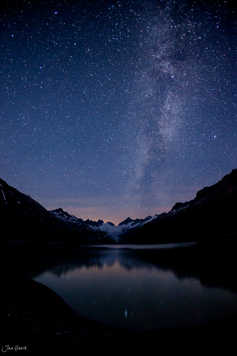 Milchstrasse über dem Grimselsee mit verschneiten Alpengipfeln bei Nacht in der Schweiz – Jan Geerk Fotograf Basel