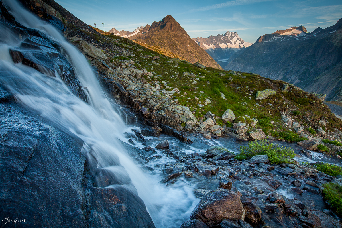 Wasserfall und Bergbach am Grimselpass mit schneebedeckten Alpen, Berner Oberland Schweiz – Jan Geerk Fotograf Basel
