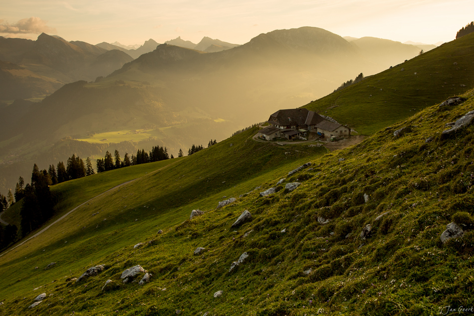 Alpenhütte auf grüner Bergwiese mit Blick auf Eiger, Jungfrau und Mönch im goldenen Morgenlicht, Berner Oberland Schweiz – Jan Geerk Fotograf Basel