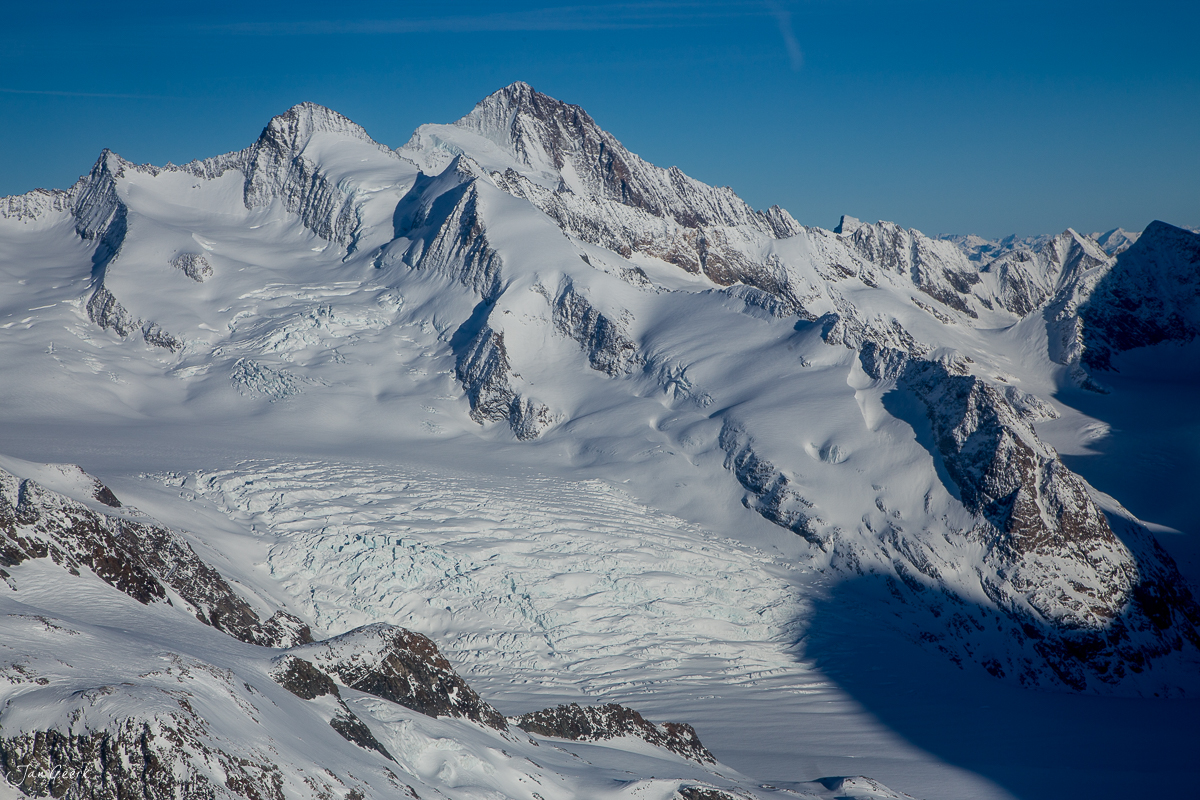 Schneebedeckte Alpengipfel und Gletscher im Berner Oberland im Winter, Luftaufnahme aus Helikopter, Schweiz – Jan Geerk Fotograf Basel