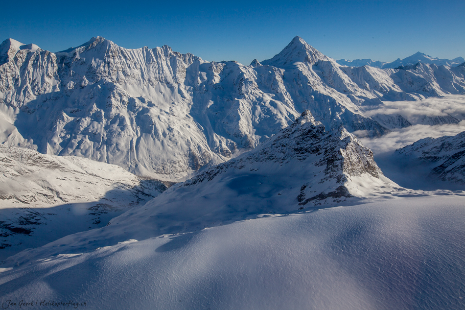 Schneebedeckte Berggipfel im Berner Oberland mit klarem Himmel, Luftaufnahme aus Helikopter – Jan Geerk Fotograf Basel Schweiz