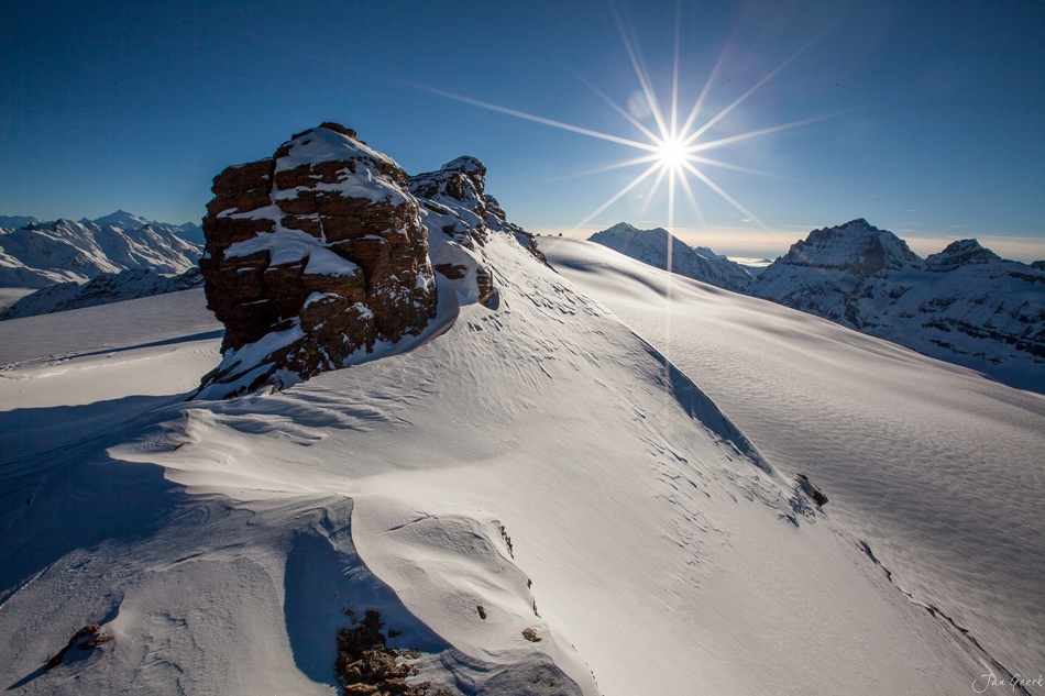Schneebedeckte Berglandschaft im Berner Oberland mit markanter Felskuppe unter strahlender Wintersonne, Helikopteraufnahme Schweiz – Jan Geerk Fotograf Basel