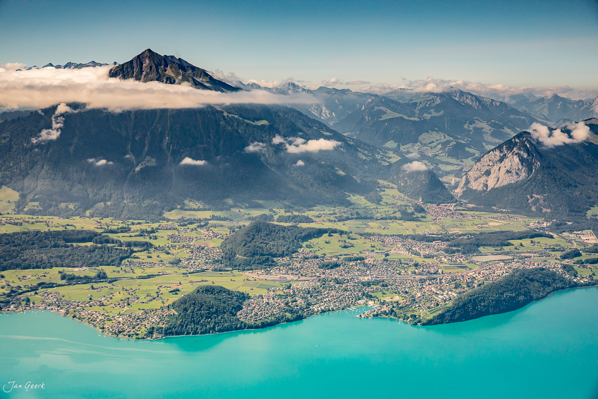 Luftaufnahme Thunersee mit türkisblauem Wasser, grünen Tälern und schneebedeckten Alpen im Berner Oberland Schweiz – Jan Geerk Fotograf Basel