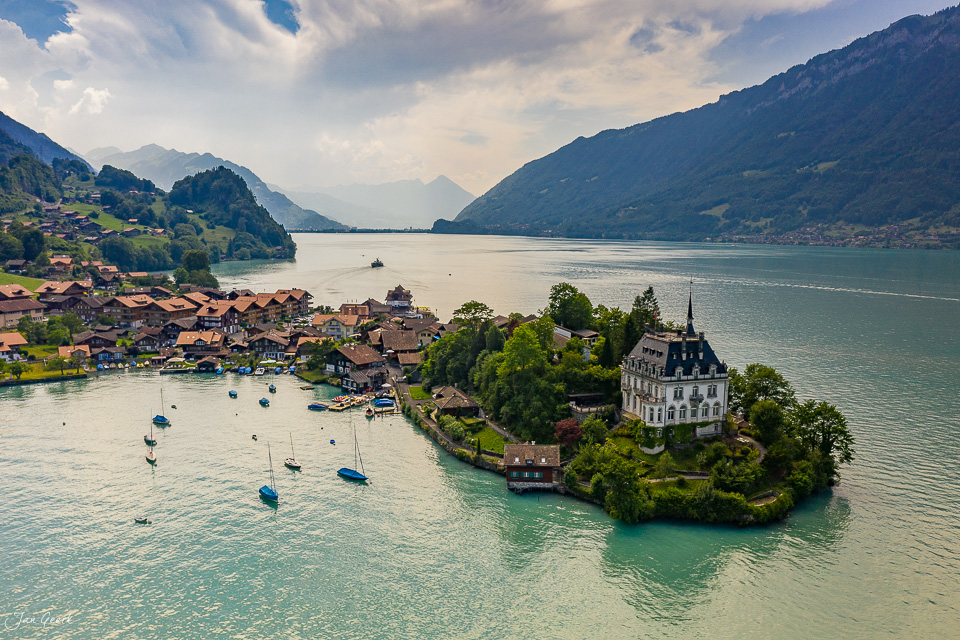 Schloss Iseltwald auf Halbinsel im Brienzersee mit Alpenpanorama Sommer Berner Oberland Schweiz Jan Geerk Fotograf Basel