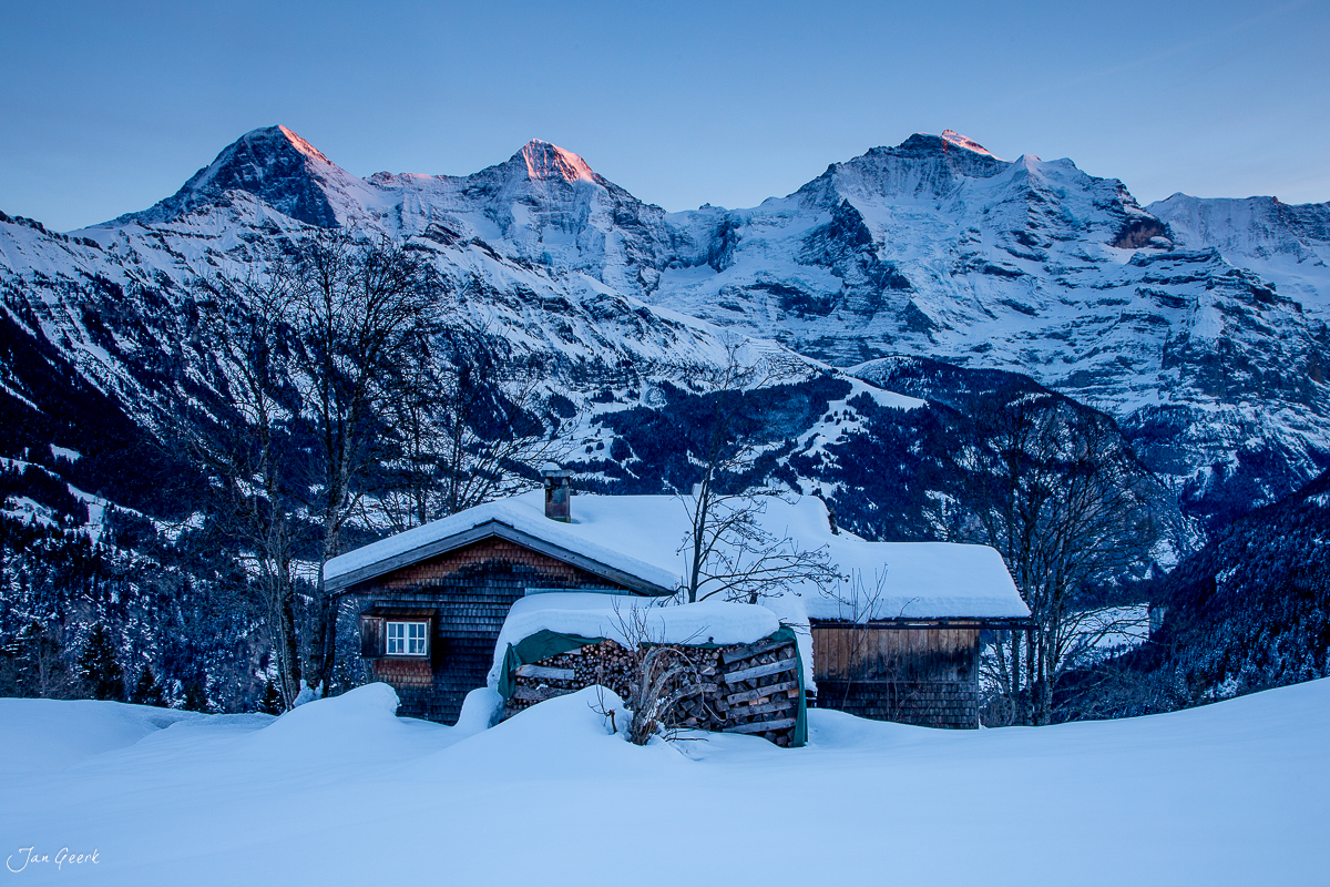 Schneebedeckte Alphütten mit Bergpanorama im Berner Oberland im Winter, Schweiz – Jan Geerk Fotograf Basel