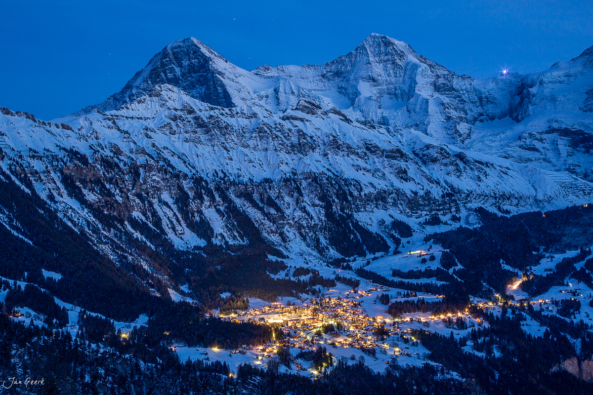 Verschneite Berglandschaft mit beleuchteter Talschaft im Berner Oberland Winter Schweiz Jan Geerk Fotograf Basel