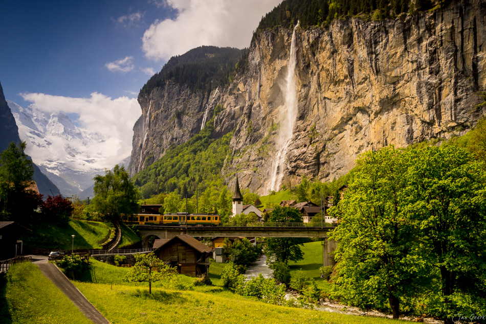 Zug auf Viadukt vor Steibach-Wasserfall im Lauterbrunnental, Frühjahr in den Alpen, Schweiz – Jan Geerk Fotograf Basel