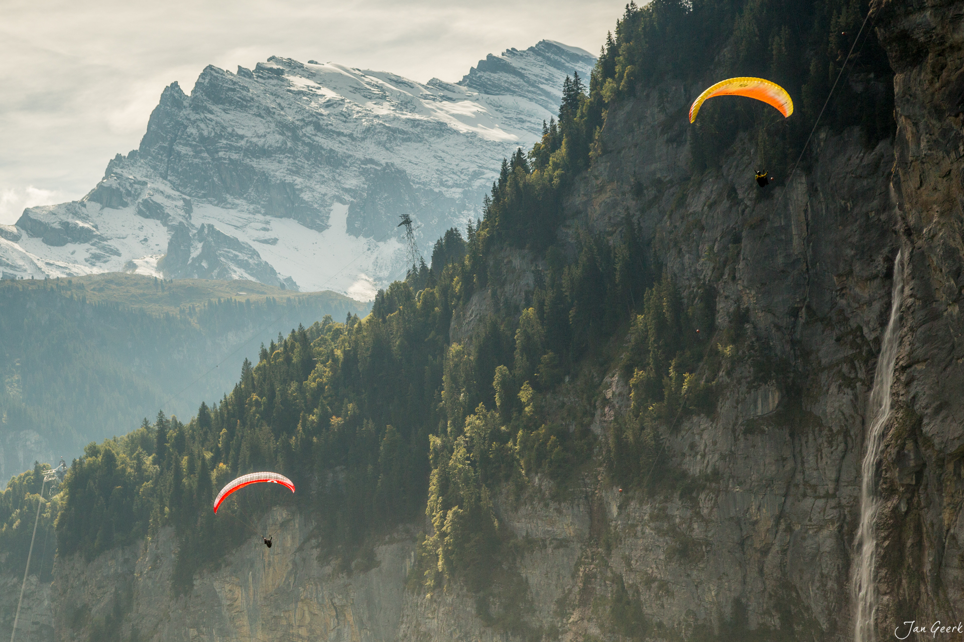 Paraglider über Lauterbrunnen mit schneebedecktem Eiger und grünen Wäldern, Herbststimmung Berner Oberland Schweiz – Jan Geerk Fotograf Basel