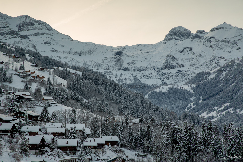 Verschneite Berghäuser und Tannenwald in Lenk im Berner Oberland bei Wintersonne – Jan Geerk Fotograf Basel