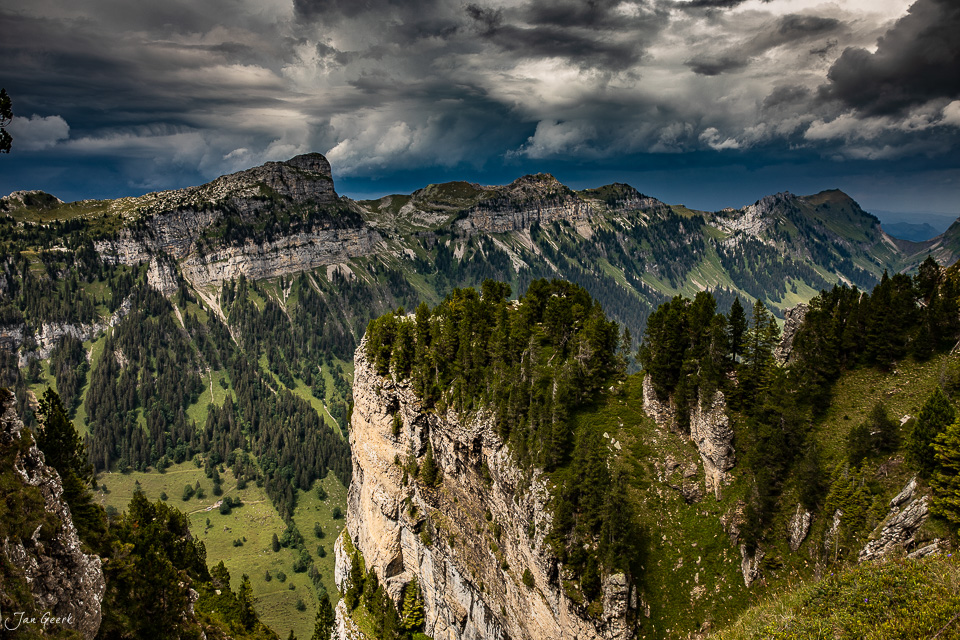 Felsige Bergketten mit Nadelwald am Niederhorn unter dramatischem Sommerhimmel, Berner Oberland Schweiz – Jan Geerk Fotograf Basel