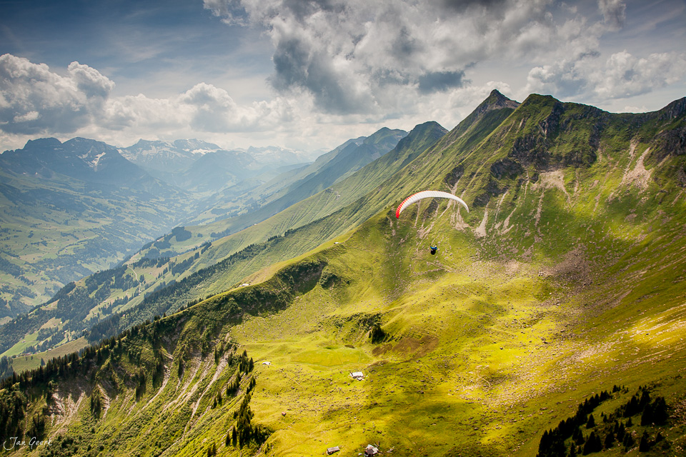 Gleitschirm über grüne Berglandschaft am Niesen mit Alpental und Sommerabendlicht in der Schweiz – Jan Geerk Fotograf Basel